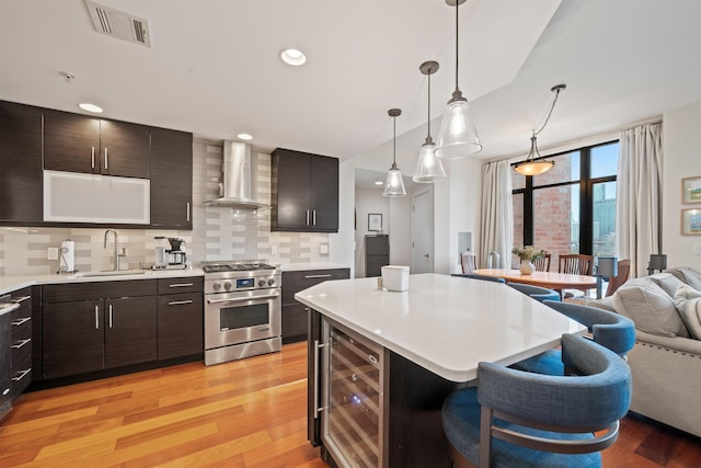 84 Willow Ave Unit 4B, Hoboken, NJ 07030 - kitchen with high end range, wine cooler, wall chimney range hood, light countertops, and recessed lighting