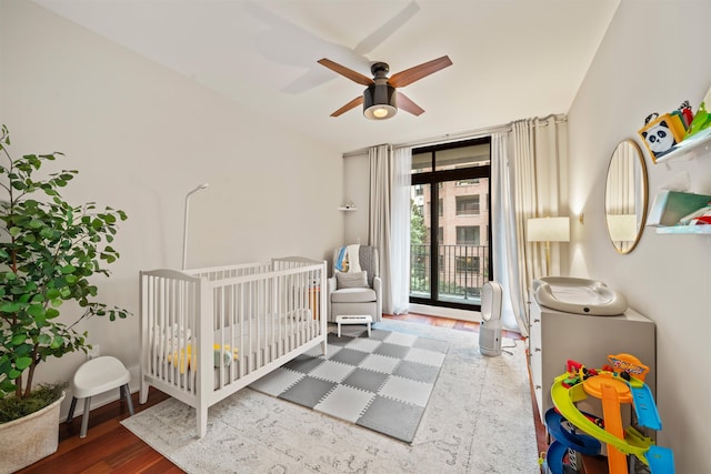 84 Willow Ave Unit 4B, Hoboken, NJ 07030 - bedroom with wood finished floors, a crib, and a ceiling fan