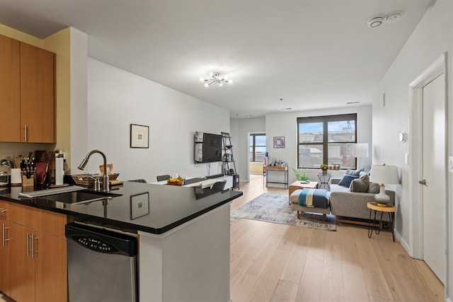 24 Ave At Port Imperial Unit 305, West New York, NJ 07093 - kitchen with light wood finished floors, stainless steel dishwasher, a sink, dark countertops, and open floor plan