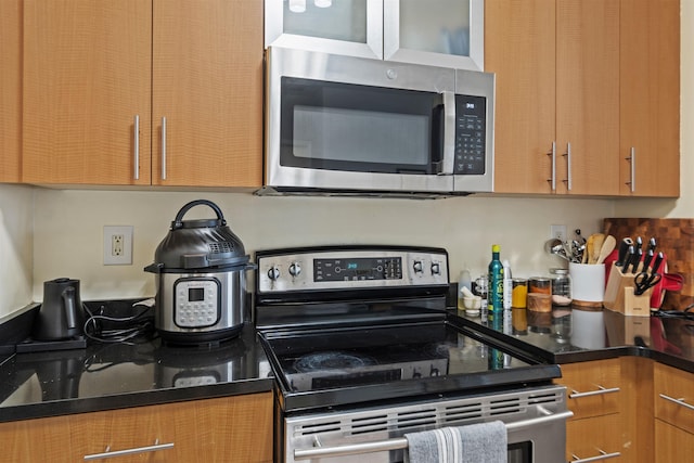 24 Ave At Port Imperial Unit 305, West New York, NJ 07093 - kitchen featuring dark countertops, brown cabinetry, and appliances with stainless steel finishes