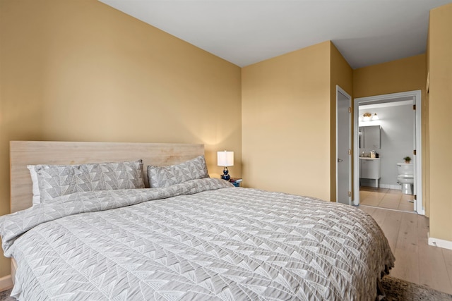 24 Ave At Port Imperial Unit 305, West New York, NJ 07093 - bedroom featuring baseboards, wood finished floors, and ensuite bathroom