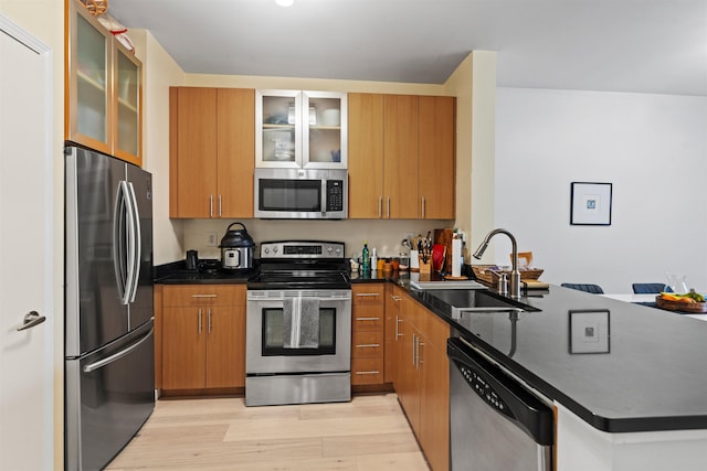 24 Ave At Port Imperial Unit 305, West New York, NJ 07093 - kitchen with a peninsula, a sink, light wood-type flooring, dark countertops, and appliances with stainless steel finishes