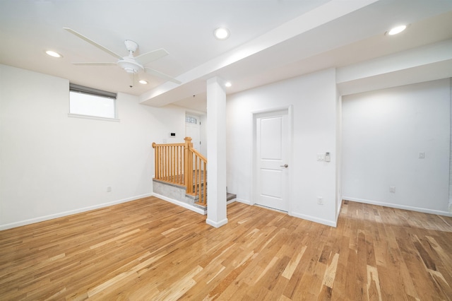 basement featuring ceiling fan and light hardwood / wood-style flooring