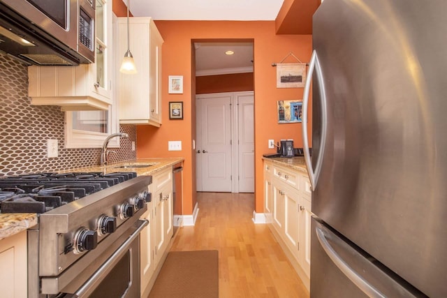 123 Tidewater St Unit B, Jersey City, NJ 07302 - kitchen with stainless steel appliances, light stone counters, light wood-style flooring, backsplash, and pendant lighting