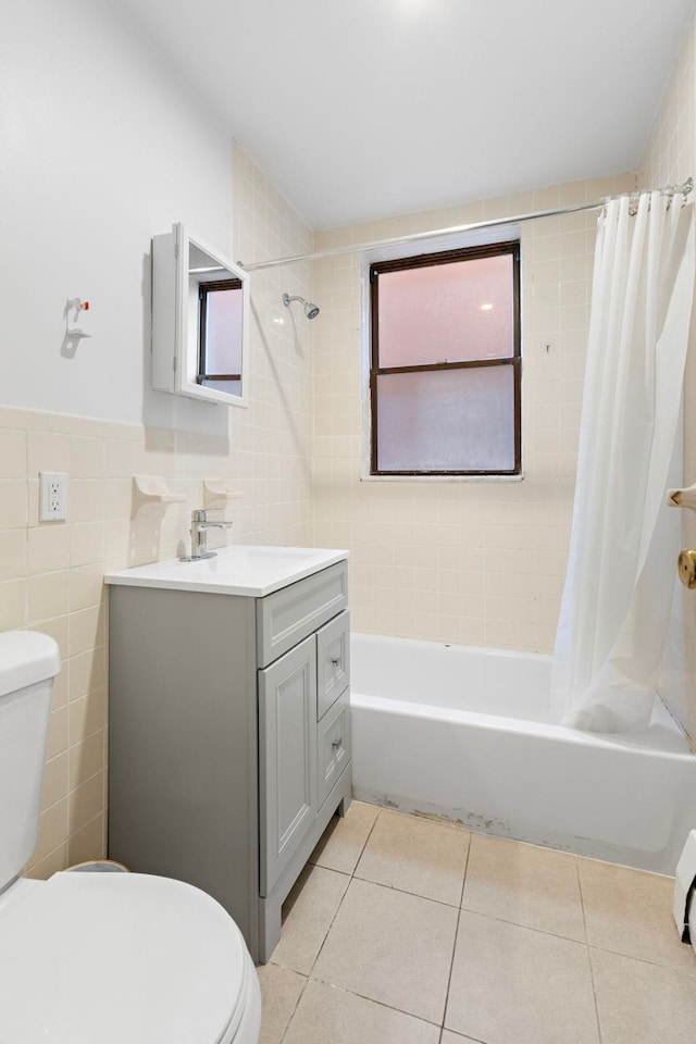 full bath with toilet, tile walls, tile patterned flooring, and shower / bath combination with curtain