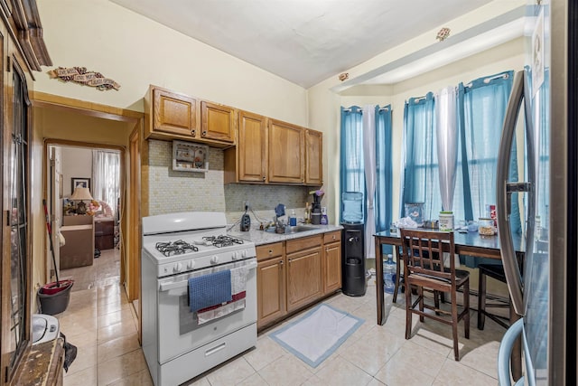 20 Martin Luther King Jr Dr, Jersey City, NJ 07305 - kitchen featuring white range with gas cooktop, freestanding refrigerator, light countertops, tasteful backsplash, and brown cabinets