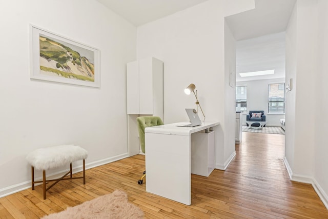 hall with light wood-style flooring and baseboards