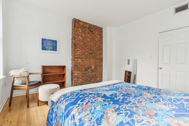 bedroom with baseboards, visible vents, and light wood-type flooring