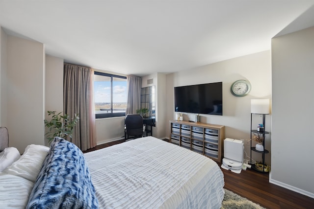 bedroom with visible vents, baseboards, and wood finished floors