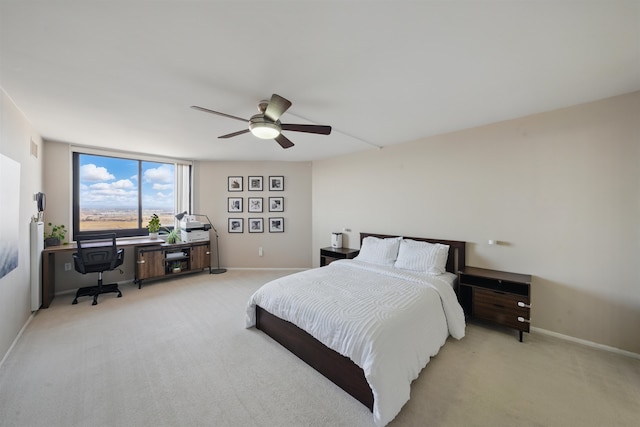 bedroom with light carpet, ceiling fan, and baseboards