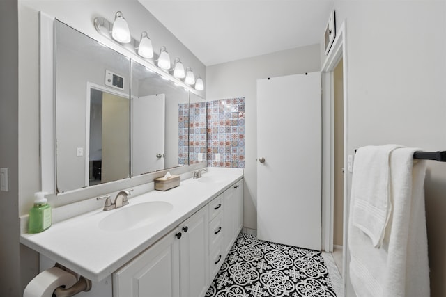 full bath with double vanity, tile patterned flooring, and a sink