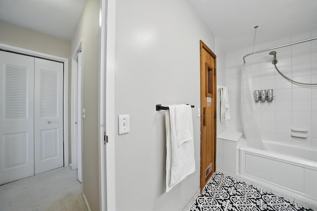 bathroom featuring a closet and shower / bath combo with shower curtain