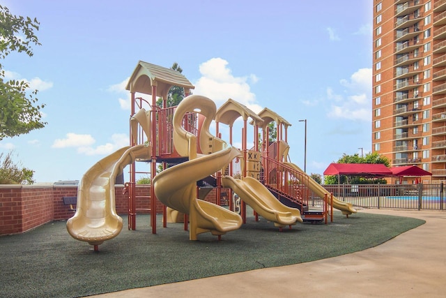 community play area featuring fence and a community pool