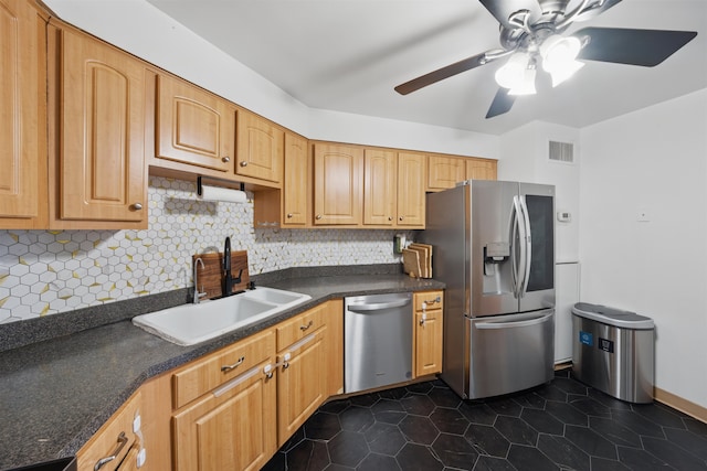 kitchen featuring dark countertops, visible vents, backsplash, appliances with stainless steel finishes, and a sink