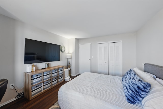 bedroom featuring dark wood-style floors, a closet, and baseboards