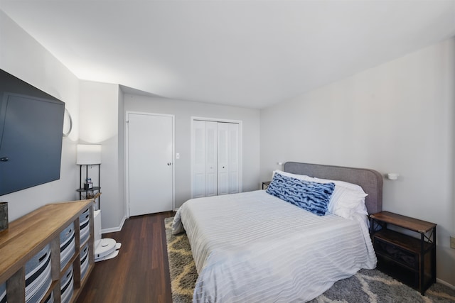 bedroom featuring a closet, dark wood-style flooring, and baseboards