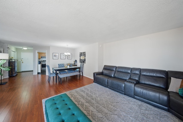 living area featuring a textured ceiling, hardwood / wood-style floors, and an inviting chandelier