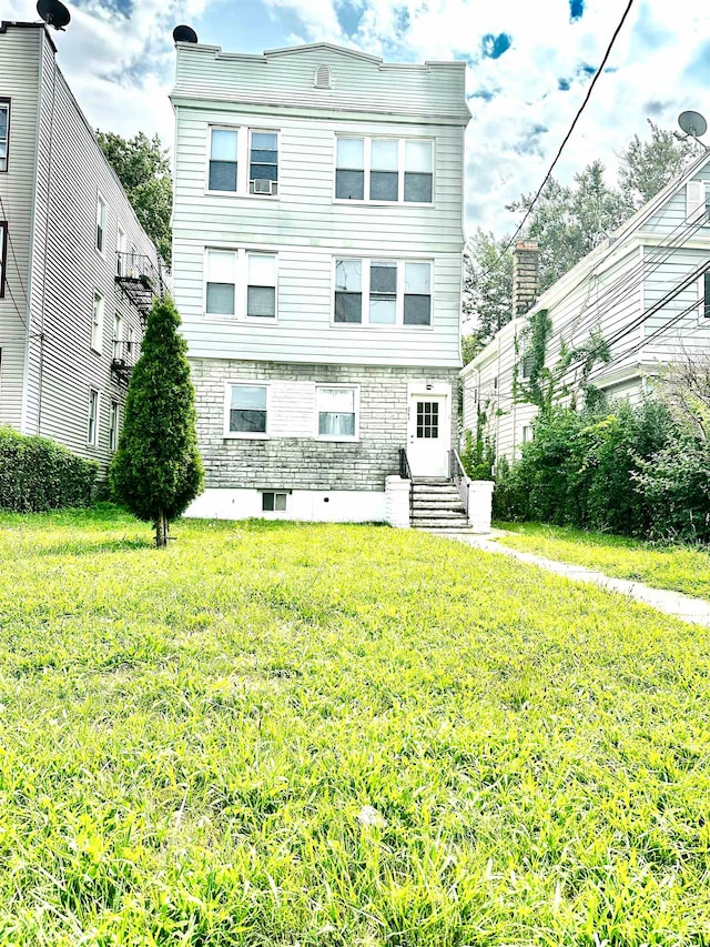 rear view of property featuring a lawn