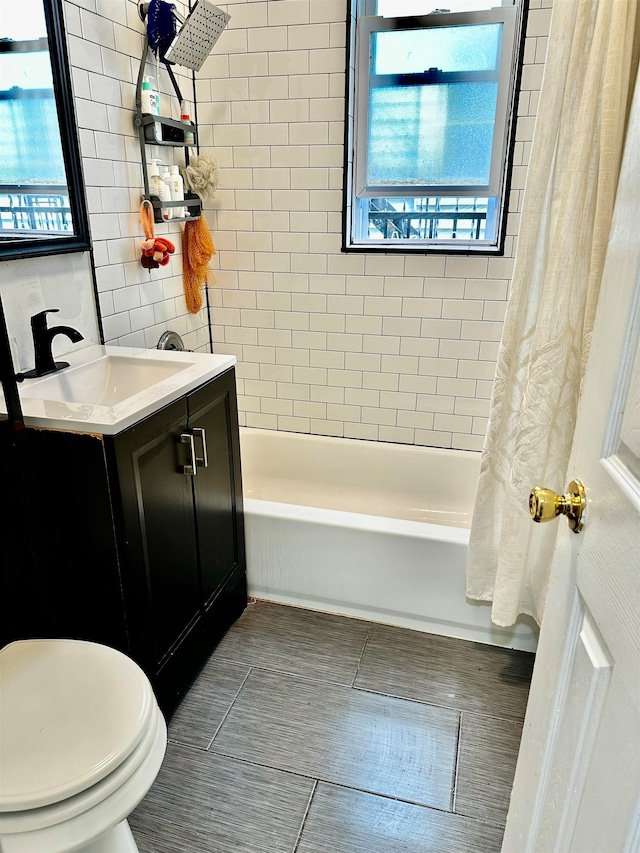 full bathroom with tile patterned flooring, vanity, shower / bath combo with shower curtain, and toilet