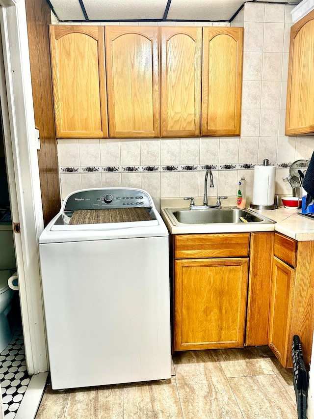 washroom featuring cabinets, sink, and washer / dryer