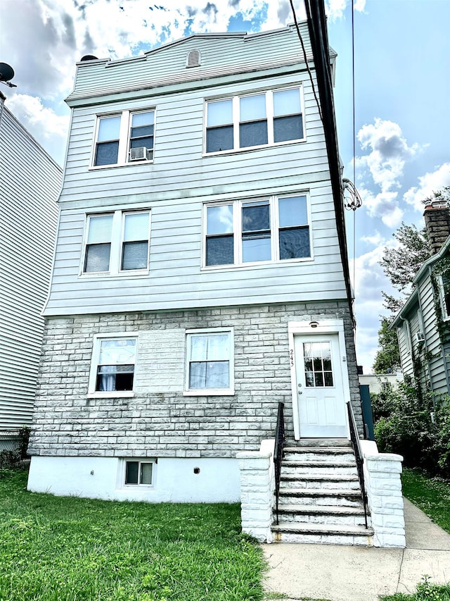 view of front of property with a front lawn and cooling unit