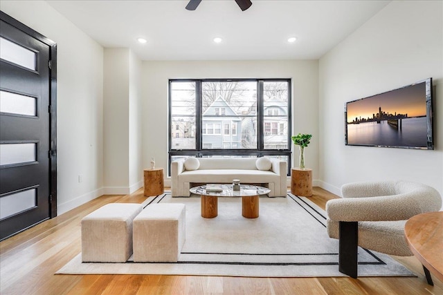 living room featuring light wood-type flooring and ceiling fan