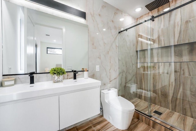 bathroom featuring toilet, a shower with door, and vanity