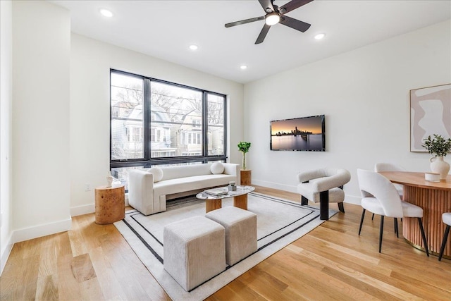 living room featuring ceiling fan and light hardwood / wood-style flooring