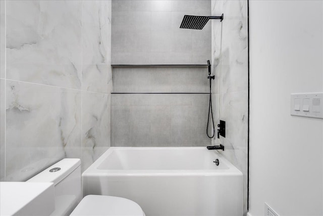 bathroom featuring toilet and tiled shower / bath combo