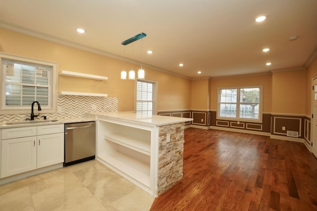 kitchen with dishwasher, sink, kitchen peninsula, decorative light fixtures, and white cabinets