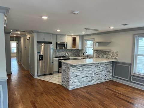 kitchen featuring a wealth of natural light, sink, wood-type flooring, and appliances with stainless steel finishes