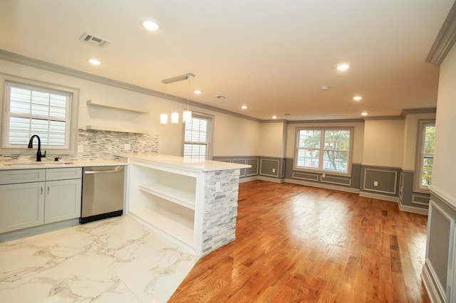 kitchen with sink, stainless steel dishwasher, backsplash, pendant lighting, and light wood-type flooring