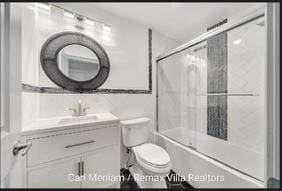 full bathroom with vanity, toilet, and enclosed tub / shower combo