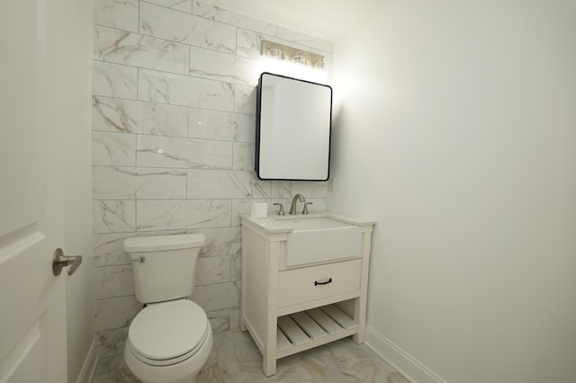 bathroom featuring vanity, toilet, and tile walls