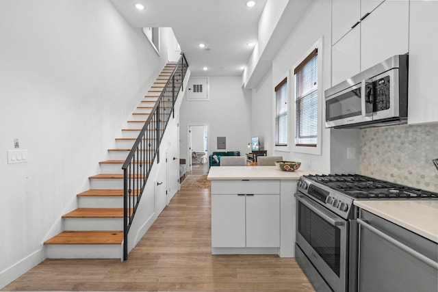 35 Manhattan Ave Unit 4, Jersey City, NJ 07307 - kitchen featuring appliances with stainless steel finishes, recessed lighting, light countertops, decorative backsplash, and white cabinetry