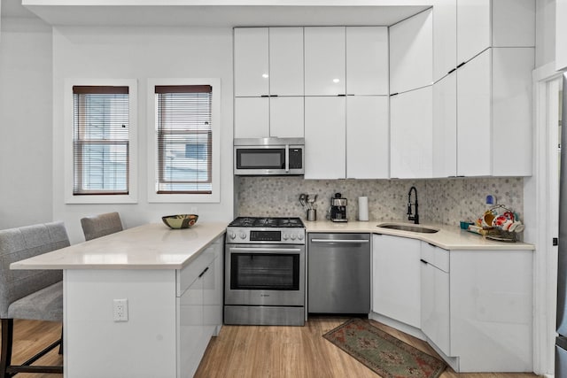 35 Manhattan Ave Unit 4, Jersey City, NJ 07307 - kitchen featuring stainless steel appliances, a peninsula, a breakfast bar, light wood-type flooring, and modern cabinets