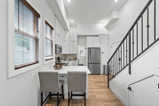 35 Manhattan Ave Unit 4, Jersey City, NJ 07307 - kitchen with appliances with stainless steel finishes, white cabinets, light countertops, recessed lighting, and light wood-style floors