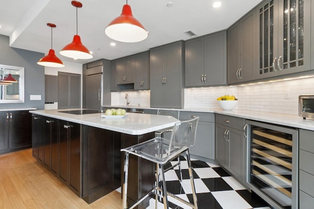 600 Harbor Blvd Unit 973/975, Weehawken, NJ 07086 - kitchen featuring beverage cooler, decorative backsplash, glass insert cabinets, black electric cooktop, and a breakfast bar
