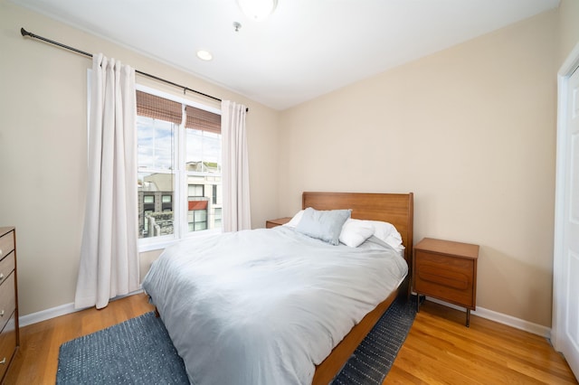 bedroom with baseboards, recessed lighting, and wood finished floors
