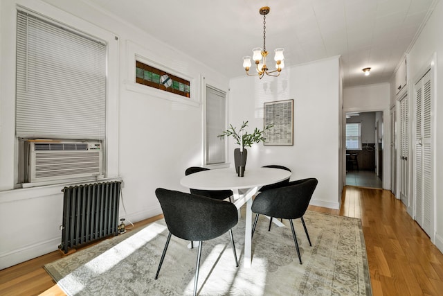 388 Kennedy Blvd, Bayonne, NJ 07002 - dining space featuring radiator, a chandelier, wood finished floors, cooling unit, and ornamental molding