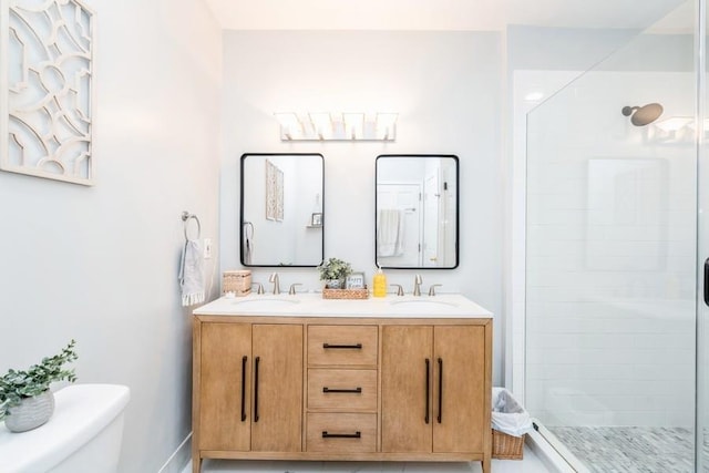 bathroom featuring a shower stall, toilet, and a sink