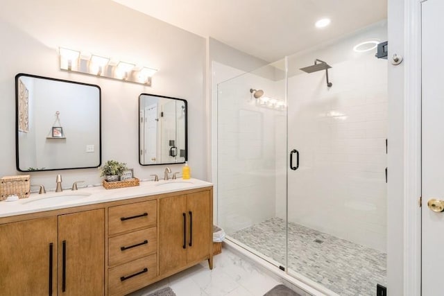 bathroom with a sink, marble finish floor, a stall shower, and double vanity