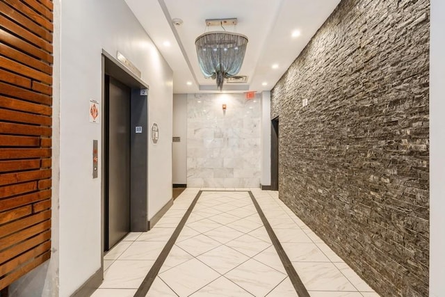 hallway with elevator, recessed lighting, marble finish floor, and baseboards