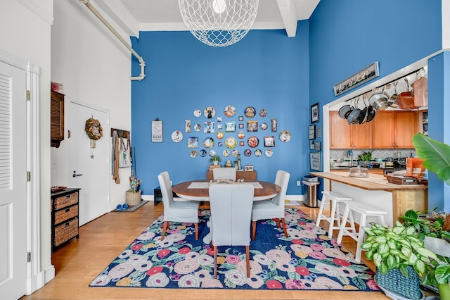 dining area featuring a high ceiling and wood finished floors
