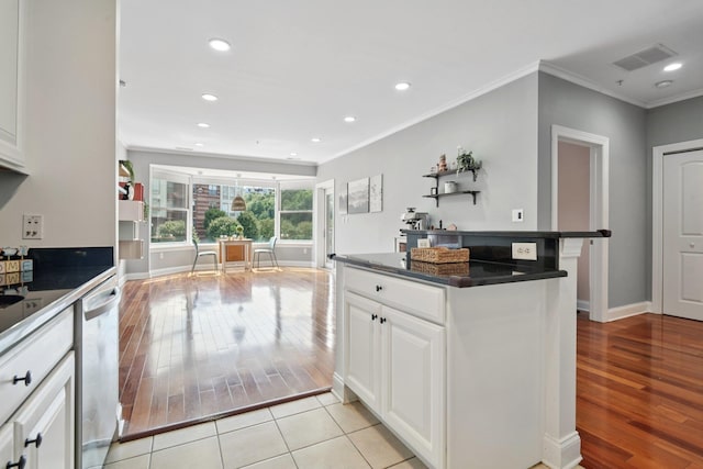 22 Ave At Port Imperial Unit 227, West New York, NJ 07093 - kitchen featuring light wood-type flooring, dishwashing machine, ornamental molding, dark countertops, and white cabinetry