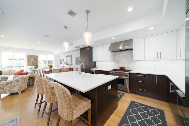 74 Madison St Unit 2, Hoboken, NJ 07030 - kitchen featuring luxury stove, wall chimney range hood, modern cabinets, a sink, and light countertops