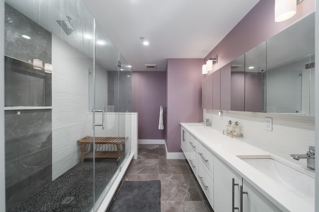 74 Madison St Unit 2, Hoboken, NJ 07030 - bathroom featuring a stall shower, baseboards, double vanity, backsplash, and marble finish flooring