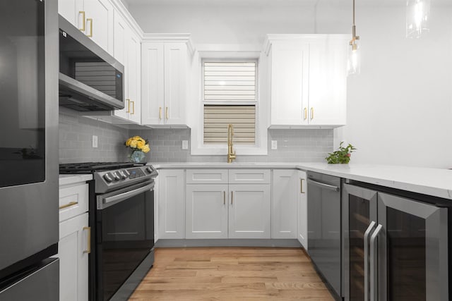119 Van Horne St Unit 1, Jersey City, NJ 07304 - kitchen with wine cooler, appliances with stainless steel finishes, tasteful backsplash, and light wood-style flooring