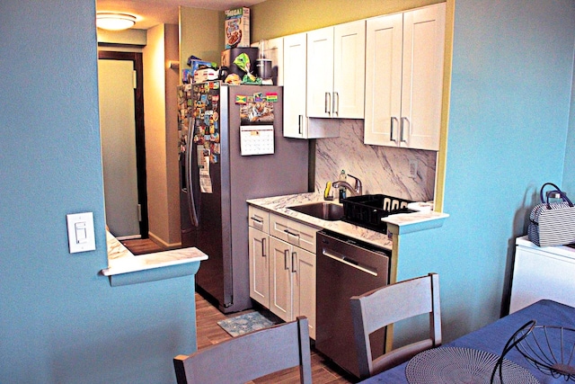 kitchen with stainless steel appliances, white cabinetry, tasteful backsplash, and light hardwood / wood-style floors