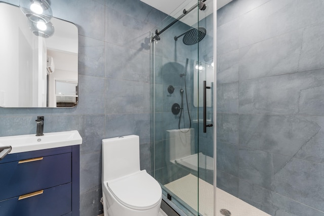 bathroom featuring toilet, a stall shower, tile walls, and vanity